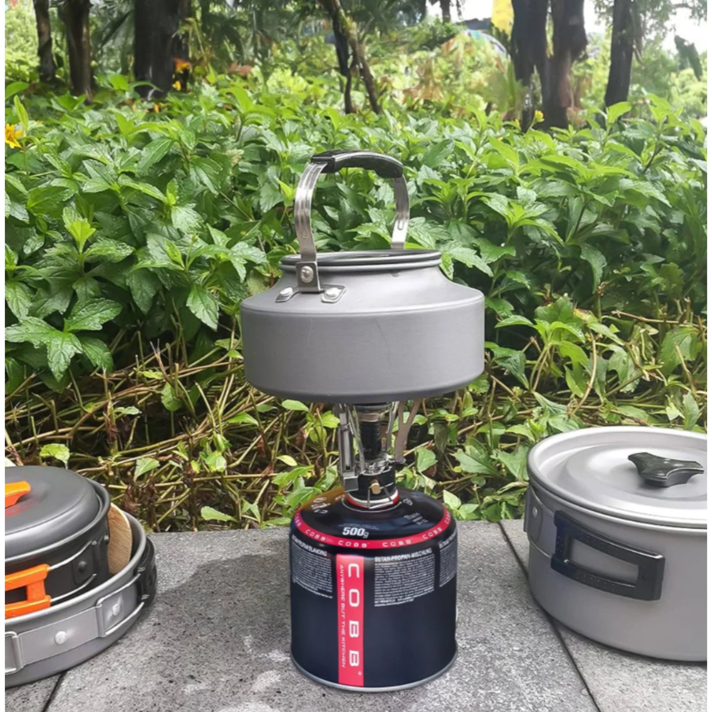 COBB 500g gas canister connected to standard screw-top camping stove for outdoor cooking use