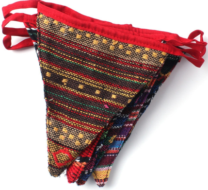Ethnic boho pennant bunting hung between tent poles at campsite adding colourful festival atmosphere to outdoor space