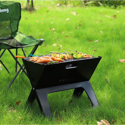 Portable grill with food on a grassy outdoor setting