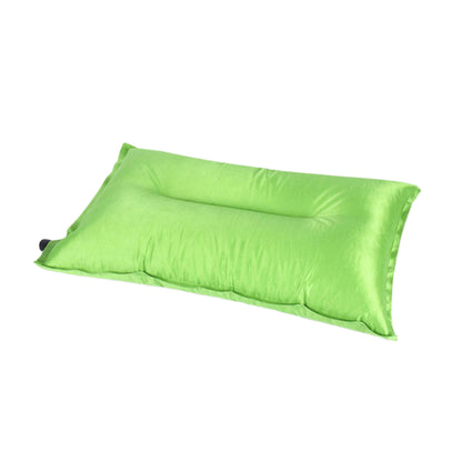Self-inflating camping pillow packed into built-in blue drawstring pouch fitting in the palm of one hand for backpacking