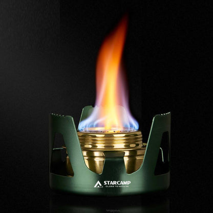 Green and gold camping stove with flame on a black background, featuring the Starcamp brand.